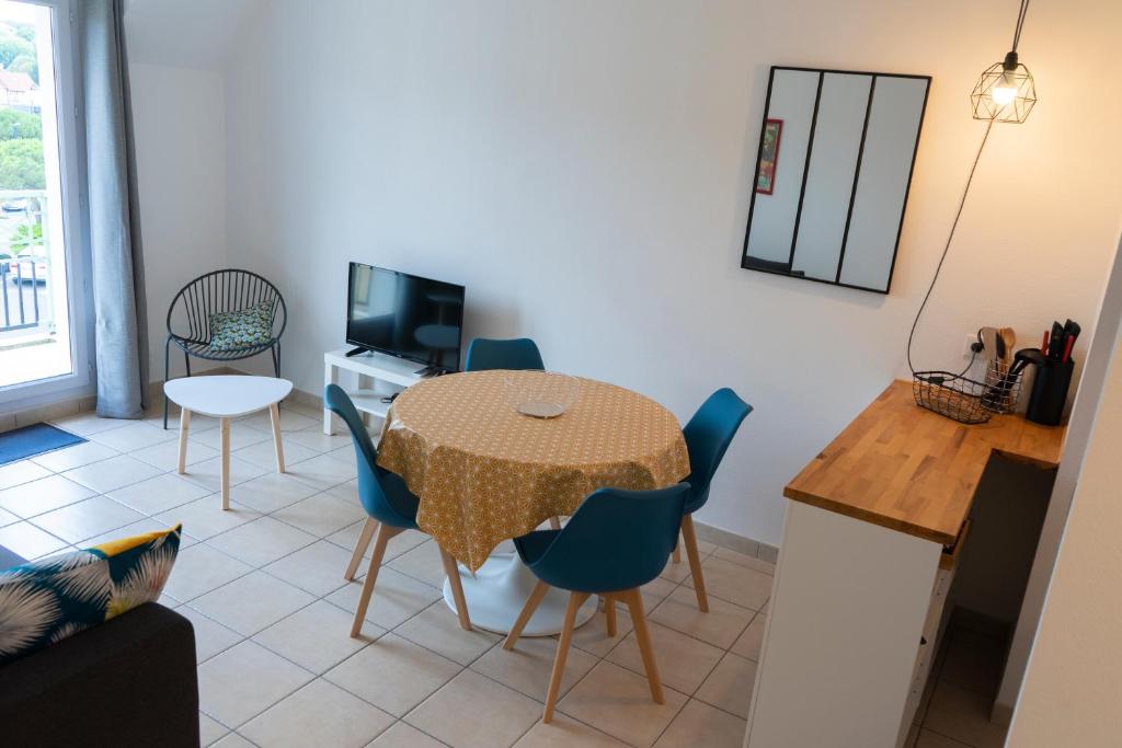 a kitchen and dining room with a table and chairs at 2 pièces Port Cabourg - 2 à 4 personnes - 34 m2 - Balcon - Vue Port - Nouveau sur Booking ! in Dives-sur-Mer
