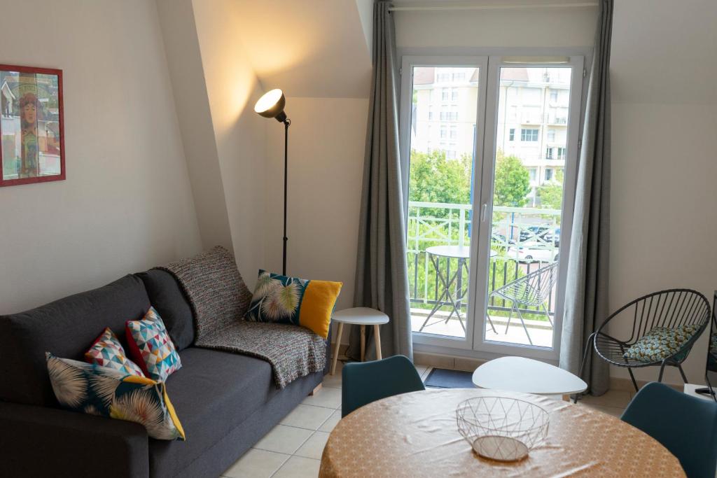 a living room with a couch and a table at 2 pièces Port Cabourg - 2 à 4 personnes - 34 m2 - Balcon - Vue Port - Nouveau sur Booking ! in Dives-sur-Mer