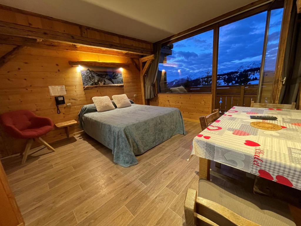 1 dormitorio con cama y ventana grande en Hotel Le Very, en Les Saisies