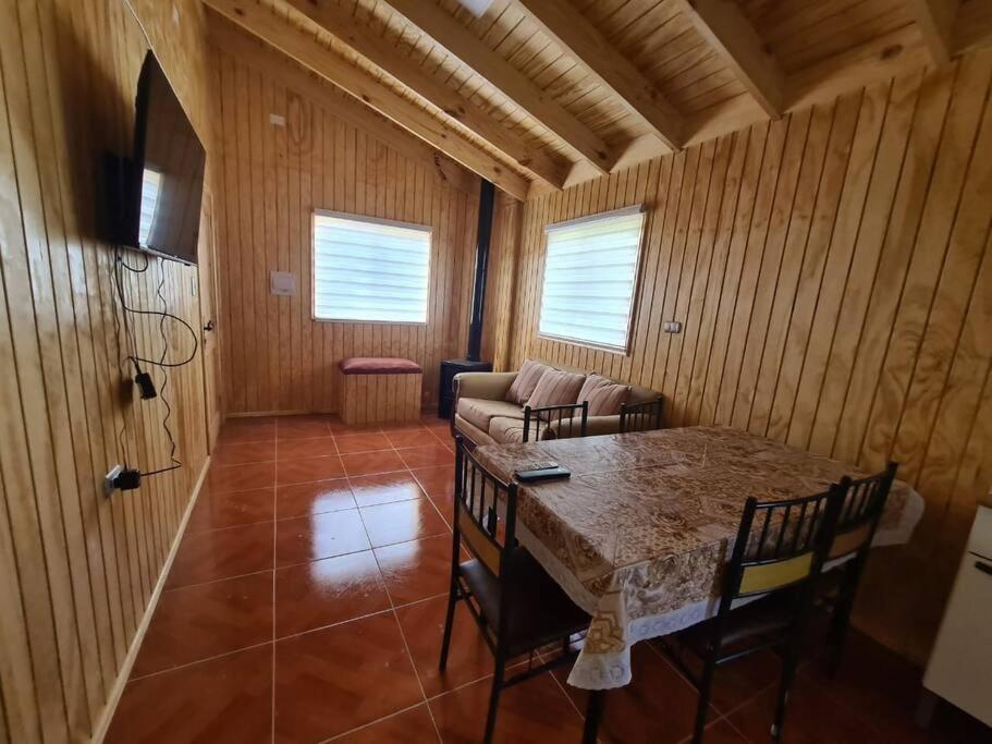 ein Wohnzimmer mit einem Tisch und einem Sofa in der Unterkunft Cabaña en Bahía Murta, equipada para 4 personas in Bahía Murta