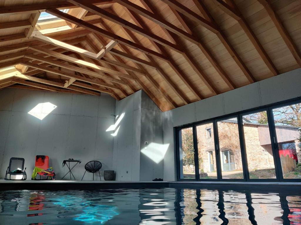 einen Innenpool mit Holzdecke in der Unterkunft Gîte avec piscine intérieure in Moyrazès