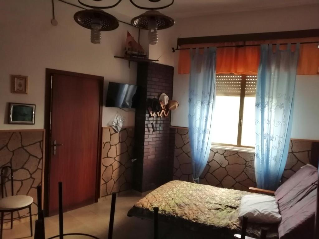 1 dormitorio con cama y ventana en "Villa Isola di MOTHIA" Piccolo appartamento 5' dal mare e aeroporto Trapani en Rilievo