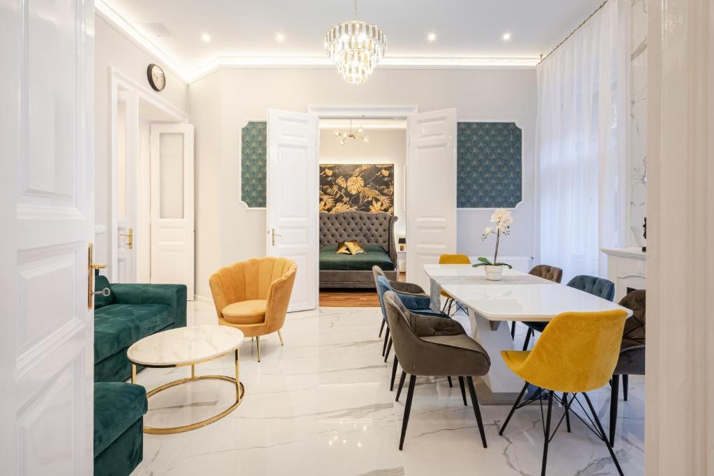 - un salon avec une table, des chaises et un canapé dans l'établissement Premium Art Deco Apartment at Broadway // 4BDR & 3BR, à Budapest