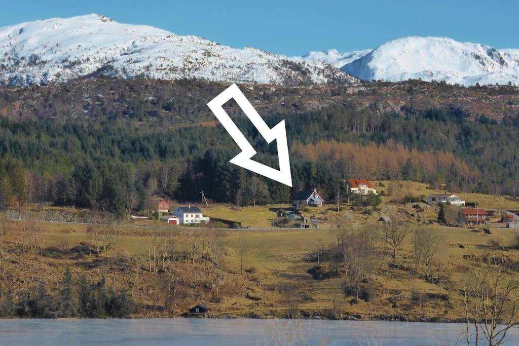 a white arrow pointing to a town in a mountain at Small Basement Apartment Private Entrance Nice View in Fitjar
