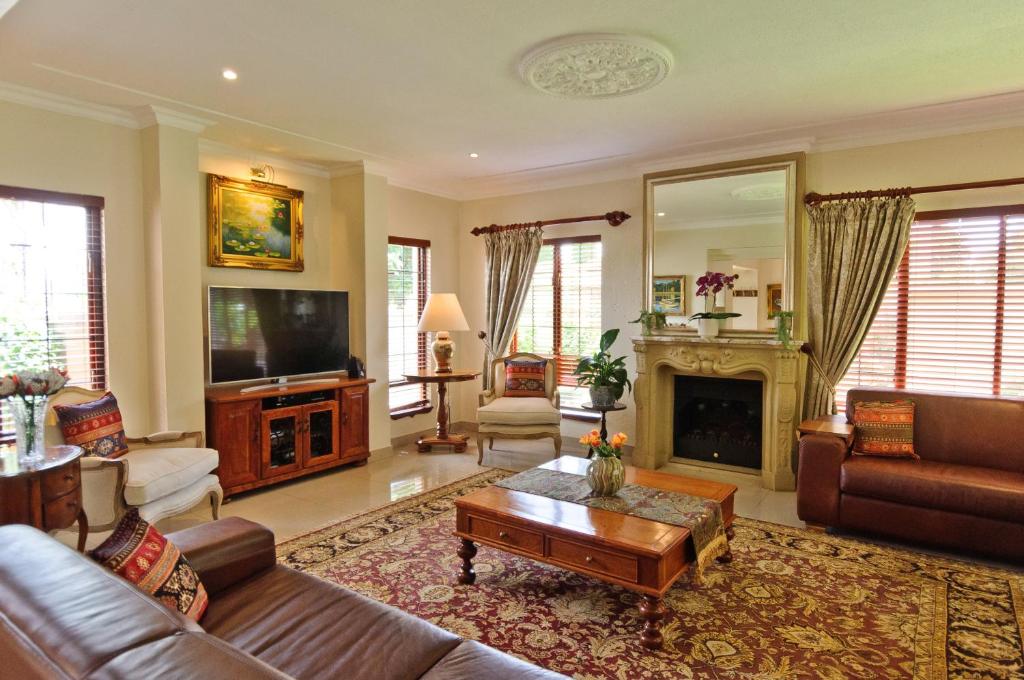 un soggiorno con divano e TV di Villa Toledo a Pretoria