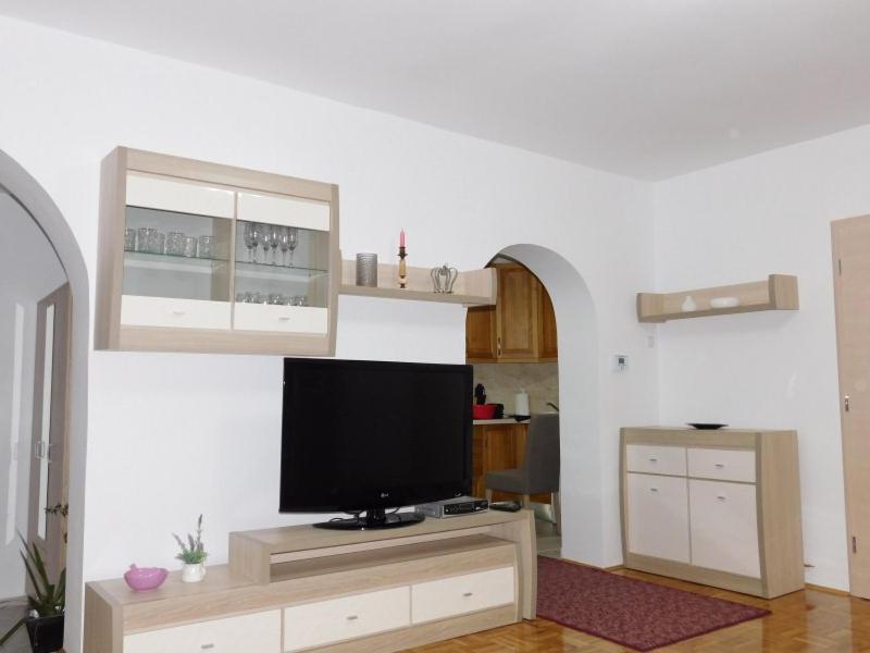 een woonkamer met een flatscreen-tv op een standaard bij Apartman Braja in Virovitica