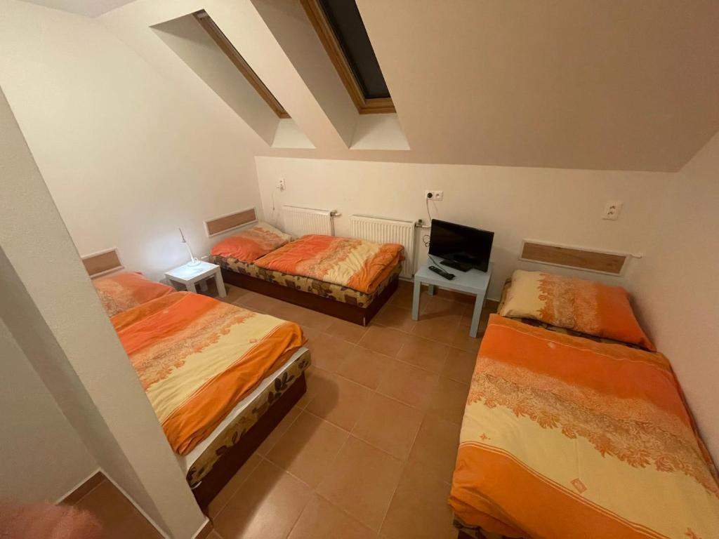 a room with two beds and a chair in it at penzión Brooklyn in Skalica