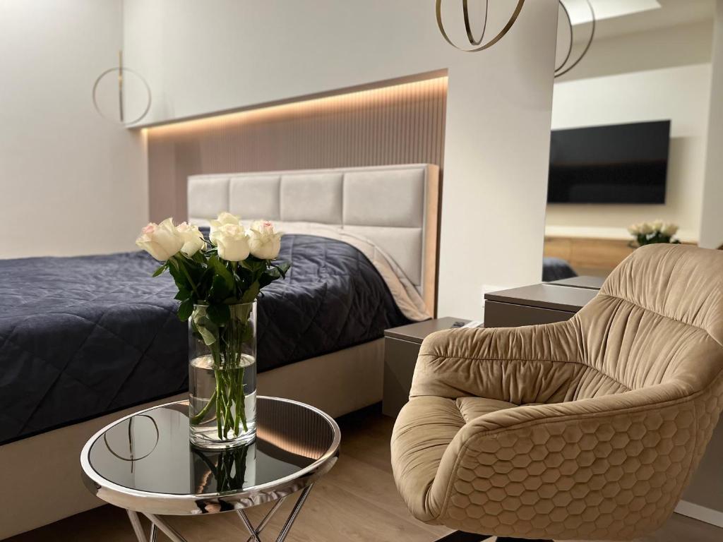 - une chambre avec un lit et un vase de fleurs sur une table dans l'établissement Oasis Luxury Apartments, à Chişinău