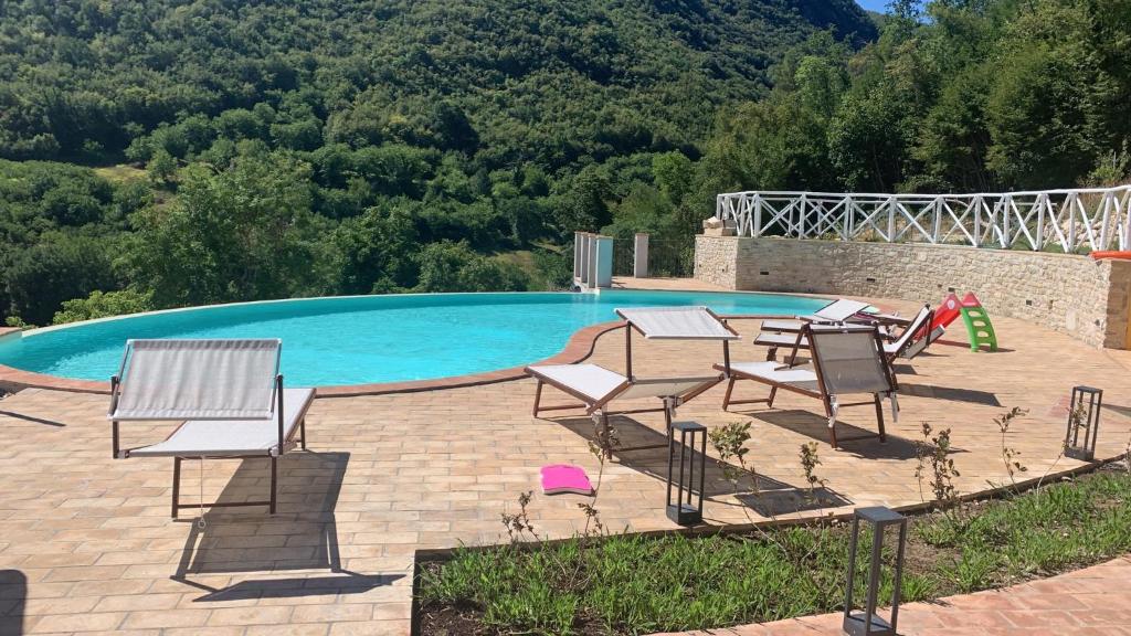 una piscina con un montón de sillas al lado en Agriturismo Pompagnano en Pompagnano