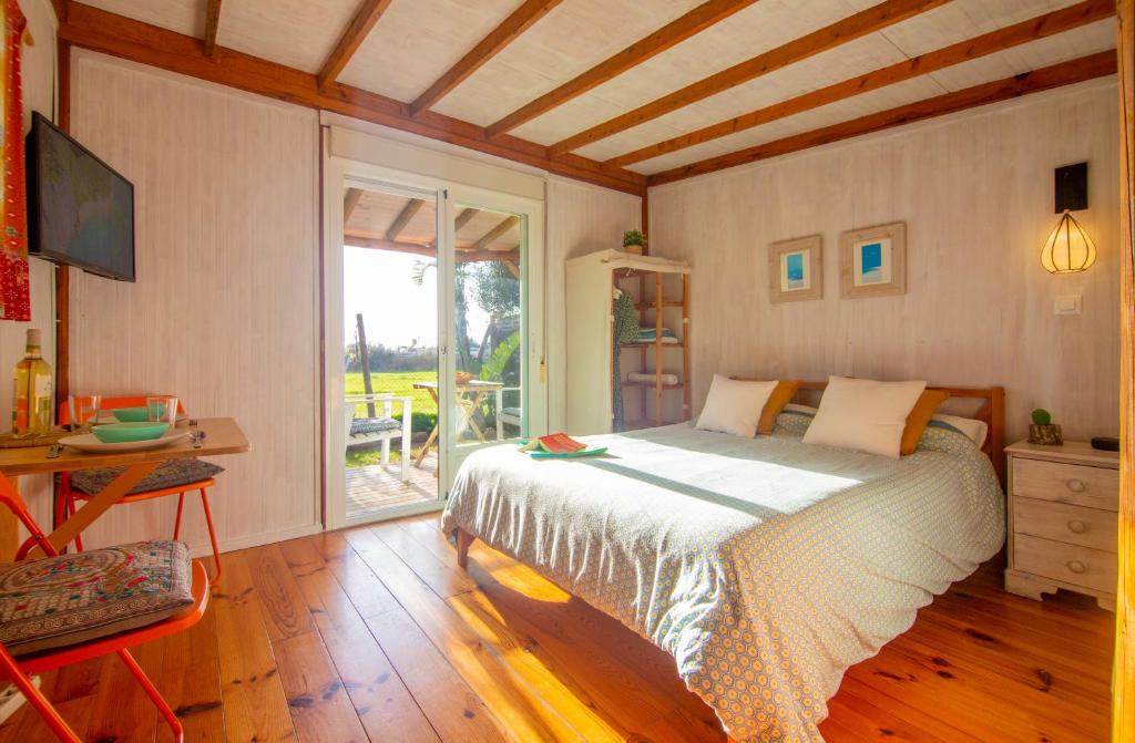 Schlafzimmer mit einem Bett, einem Tisch und einem Fenster in der Unterkunft Romantic Beach Cabin - Playa El Palmar in El Palmar