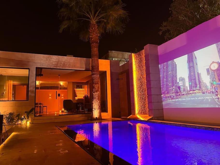 a house with a swimming pool with a palm tree at The Palms Resort (3) in Riyadh
