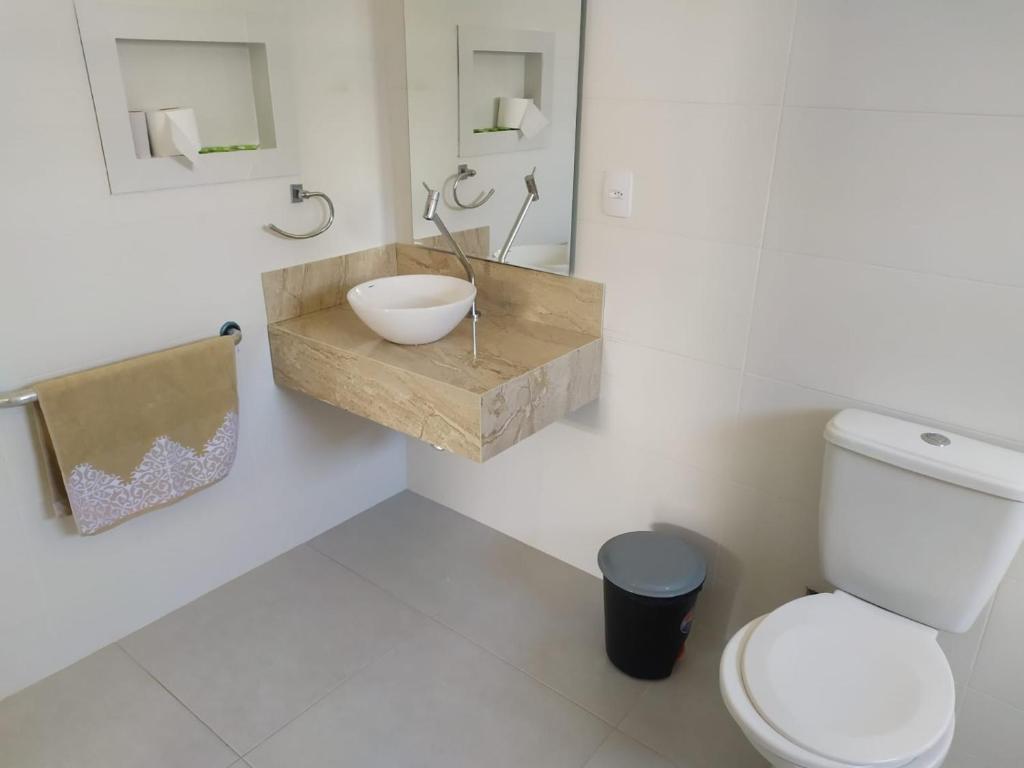 a bathroom with a bowl sink and a toilet at Pousada Castelo do Rei in Penha