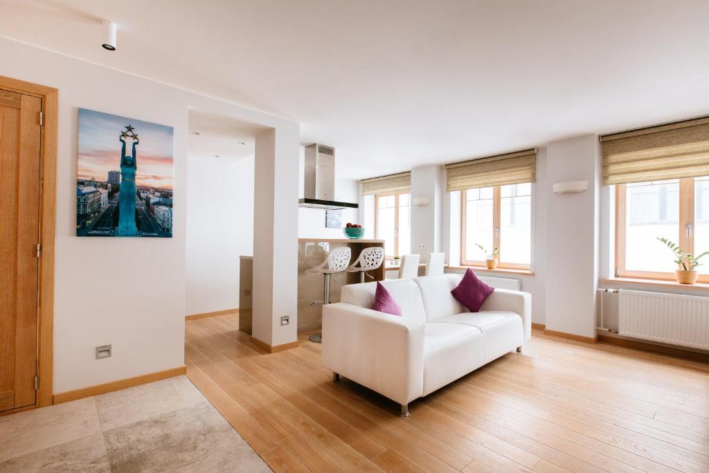 a living room with a white couch and a clock tower at New Exclusive 2 Bedroom Apartment in OldRiga in Rīga