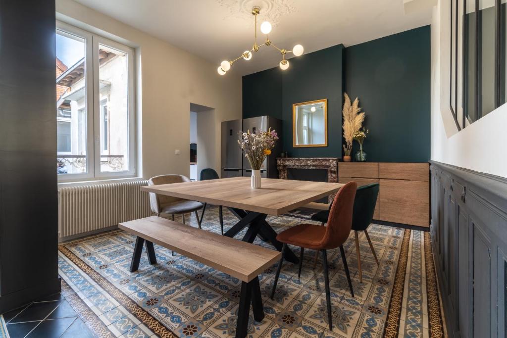 a dining room with a wooden table and chairs at L&#39;Orée du Faubourg - VENDOME CENTRE in Vendôme