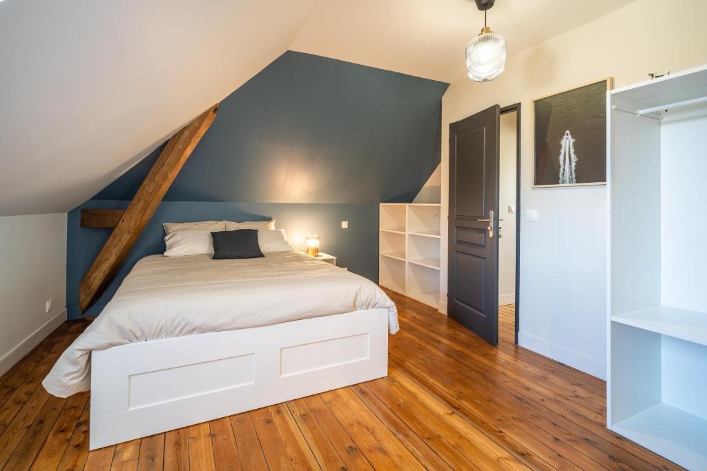 a bedroom with a white bed and blue walls at L&#39;Orée du Faubourg - VENDOME CENTRE in Vendôme