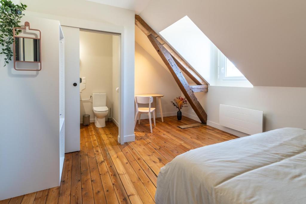 a bedroom with a bed and a table in a room at L&#39;Orée du Faubourg - VENDOME CENTRE in Vendôme