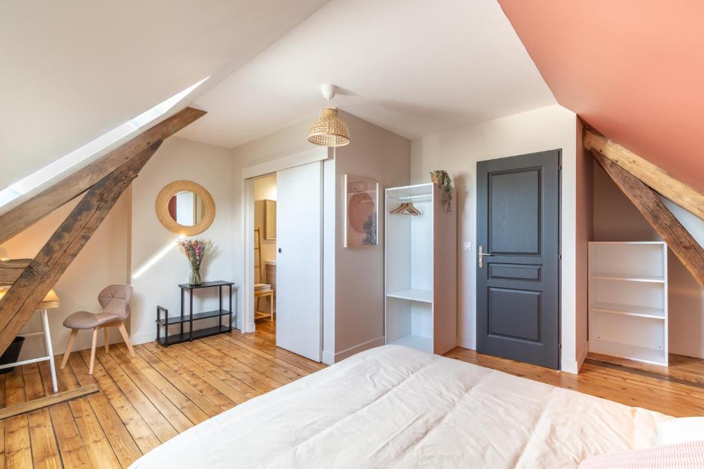 a bedroom with a white bed and a wooden floor at L&#39;Orée du Faubourg - VENDOME CENTRE in Vendôme