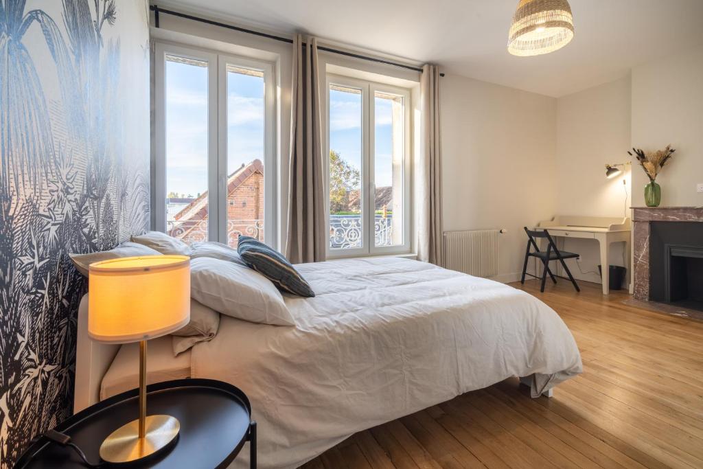 a bedroom with a bed and a large window at L&#39;Orée du Faubourg - VENDOME CENTRE in Vendôme