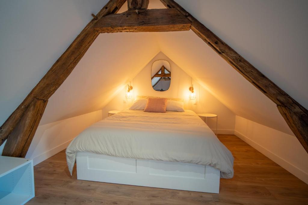 a bedroom with a white bed in the attic at L&#39;Orée du Faubourg - VENDOME CENTRE in Vendôme