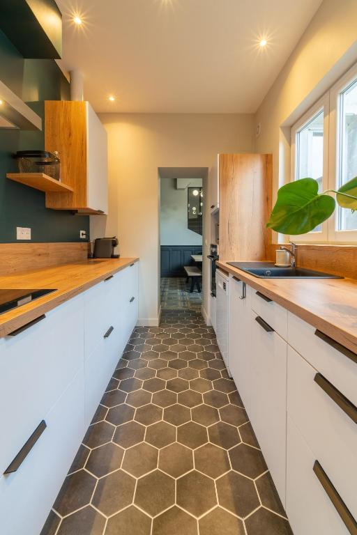 a kitchen with white cabinets and a tile floor at L&#39;Orée du Faubourg - VENDOME CENTRE in Vendôme