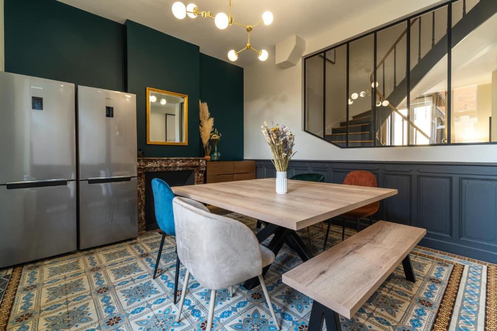 a dining room with a wooden table and blue chairs at L&#39;Orée du Faubourg - VENDOME CENTRE in Vendôme