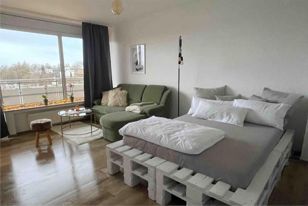 um quarto com uma cama grande e um sofá em Apartment mit schönem Ausblick em Lüdenscheid