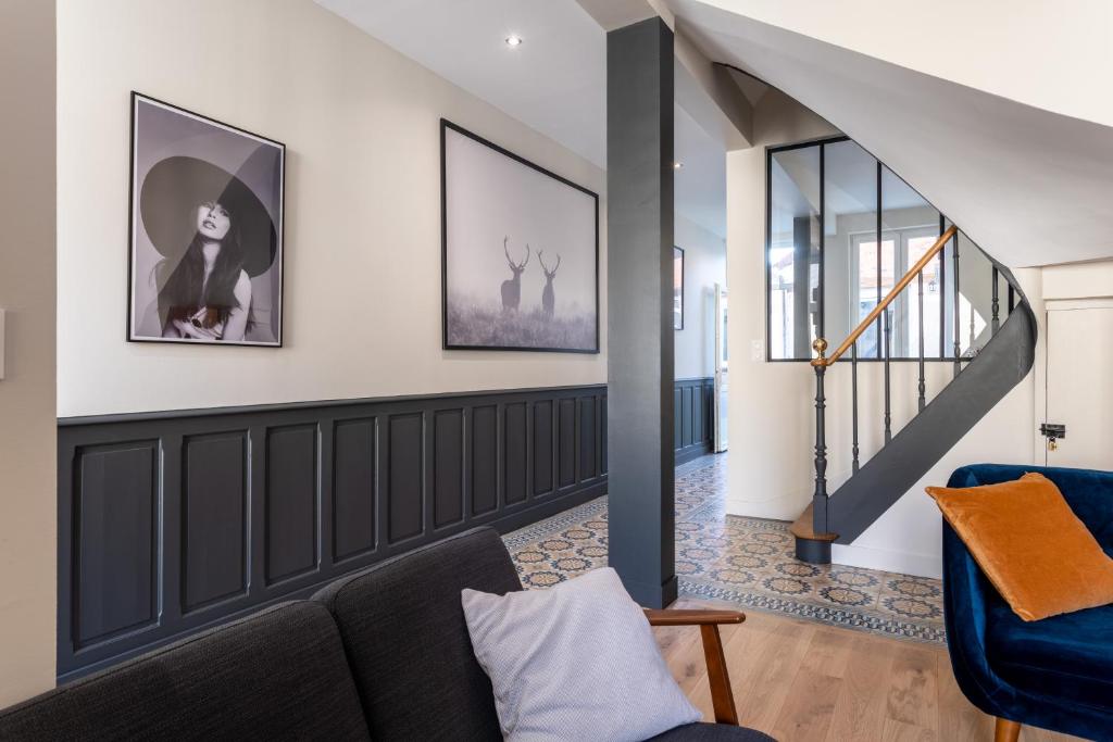 a living room with a couch and a staircase at L&#39;Orée du Faubourg - VENDOME CENTRE in Vendôme