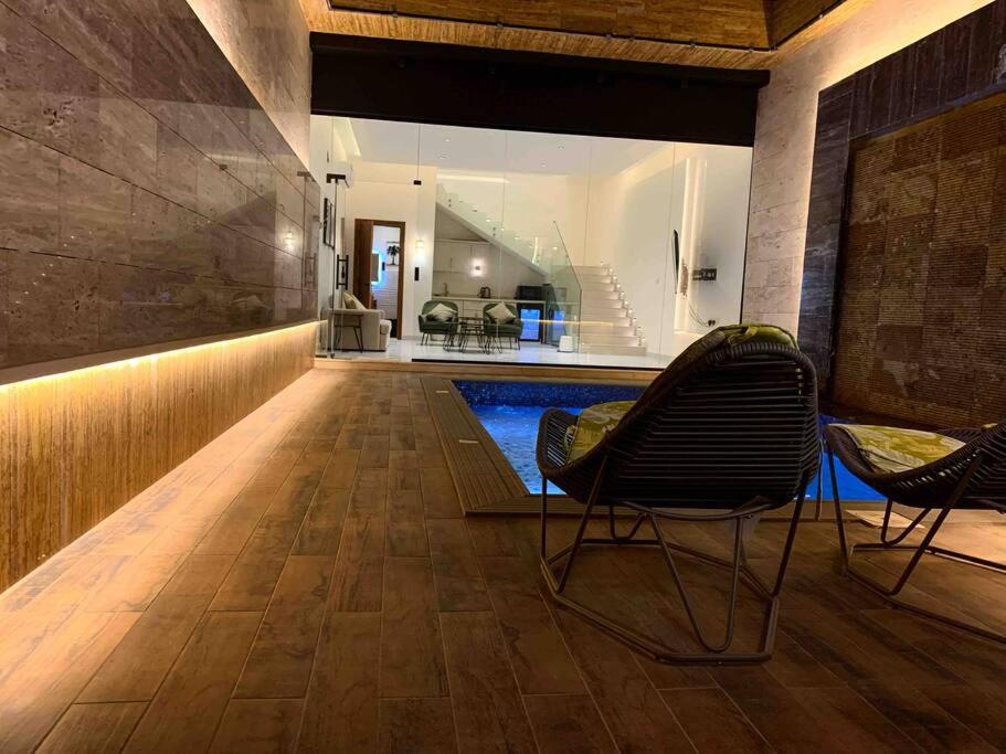 y sala de estar con piscina y 2 sillas. en The Palms Resort (2) en Riad