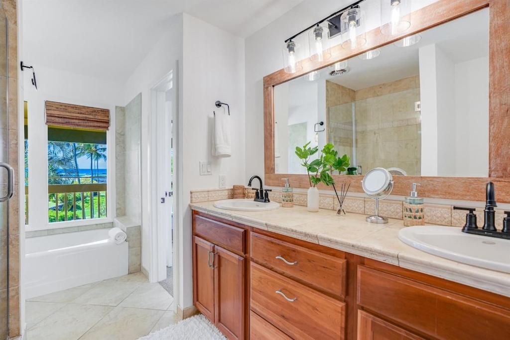 a bathroom with two sinks and a large mirror at Honu He'e Nalu - The Surfing Turtle - Ocean & Beachfront! Stunning Views! in Koloa