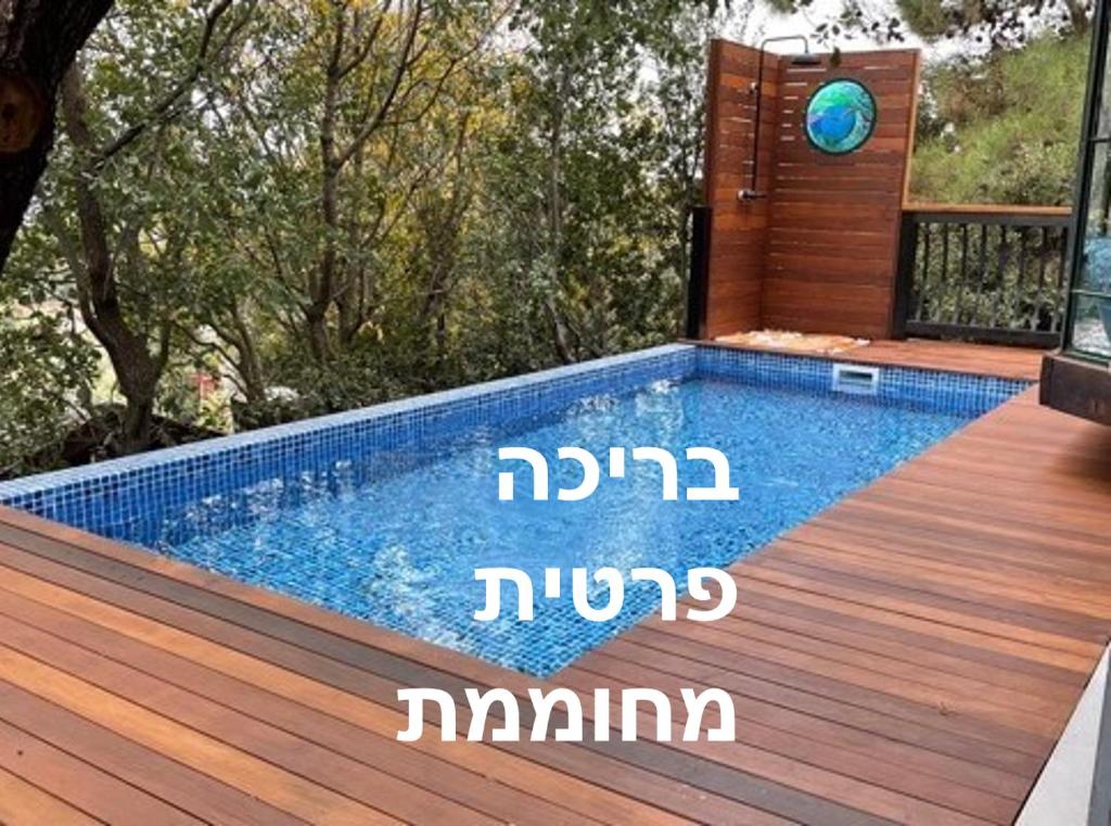una piscina su una terrazza in legno accanto a una casa di First Light Cabins ad Amirim