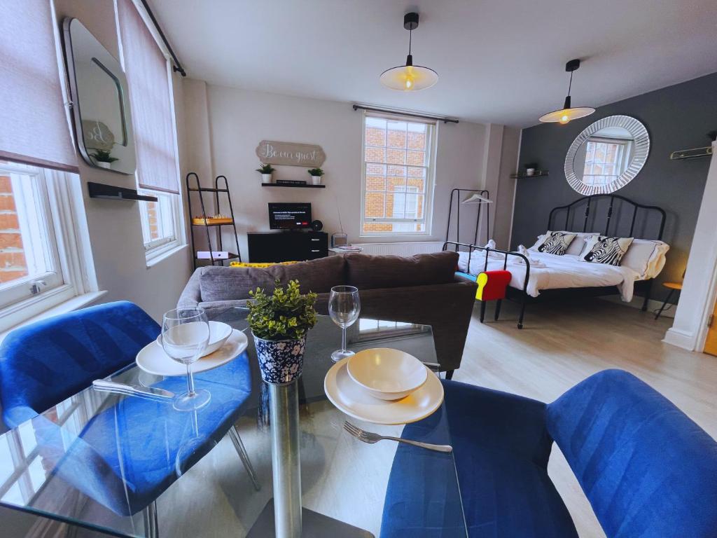 uma sala de estar com uma mesa de vidro e cadeiras azuis em Bristol City Stays - Cabot Circus em Bristol