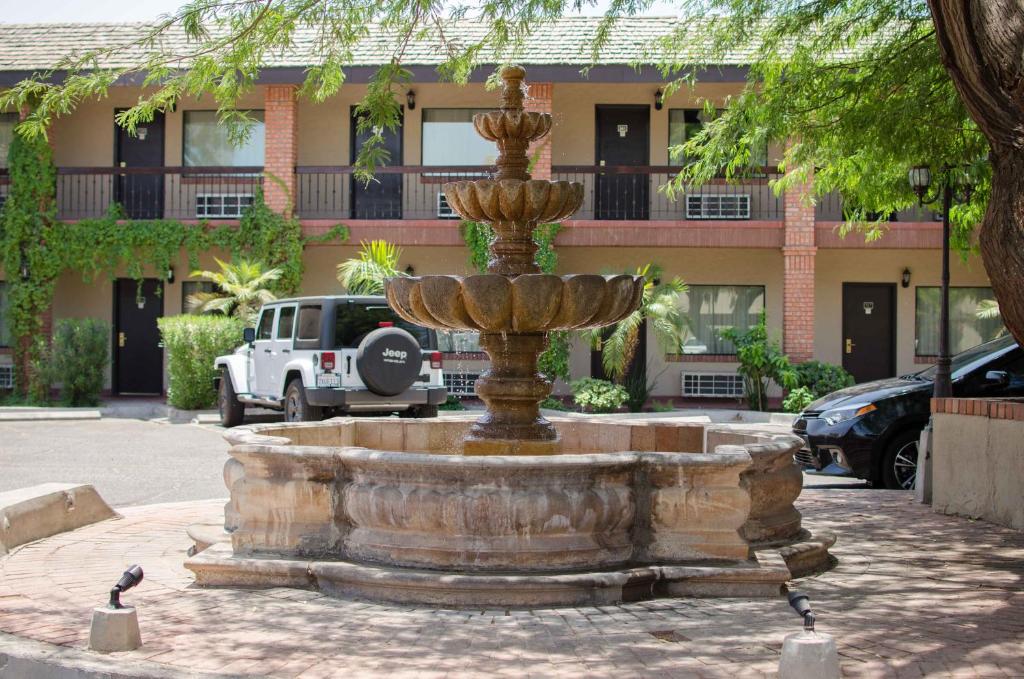 a fountain in front of a building with birds standing around it at Hotel Siesta Real in Mexicali