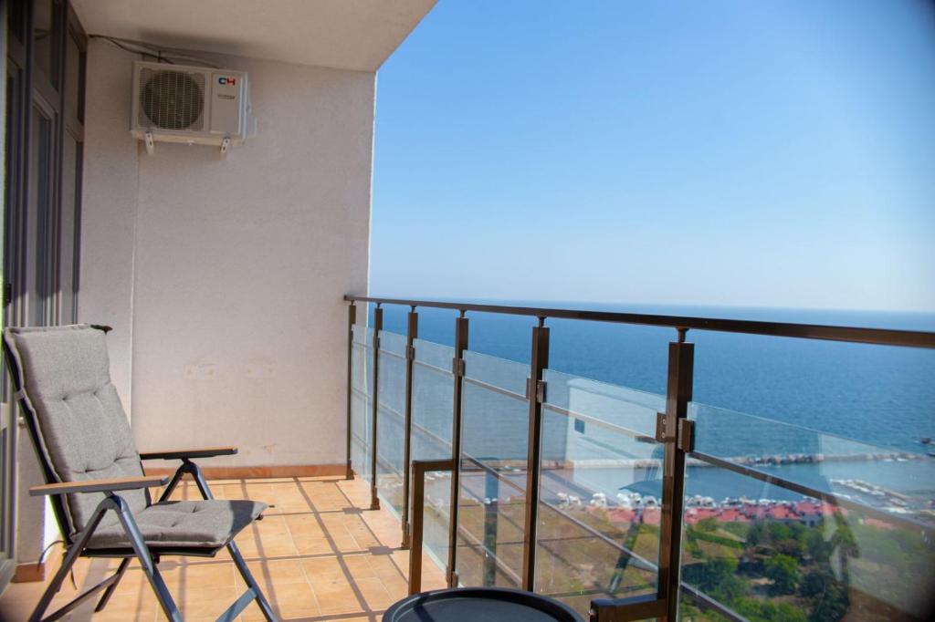 a balcony with a chair and a view of the ocean at Pearl of Arcadia on Kamanina in Odesa
