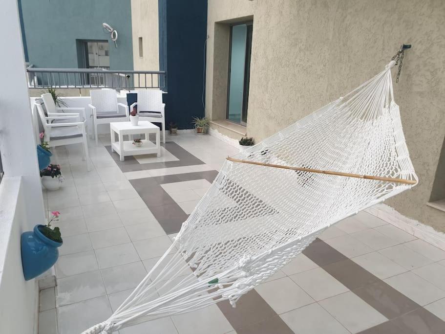 a white hammock hanging on a patio with chairs at The jewel of the coast in Sousse