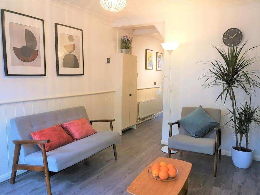 a living room with a couch and a table at Cute Cottage 4 mins from Cafés Station and Sea in St. Leonards