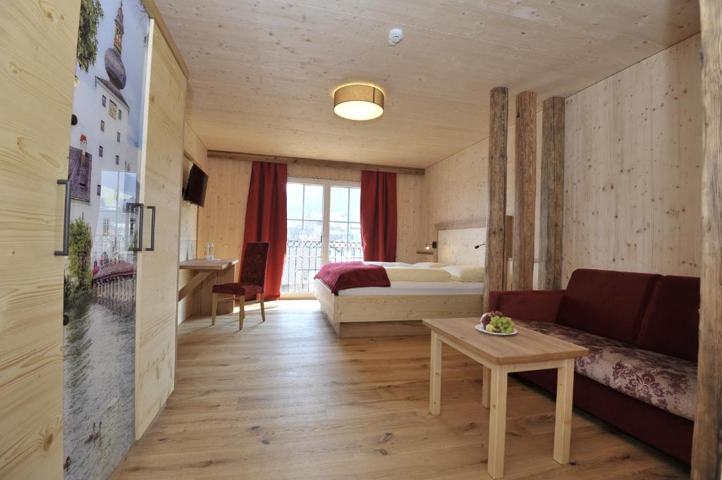 a hotel room with a bed and a couch and a table at Gasthaus Reiter in Pinsdorf