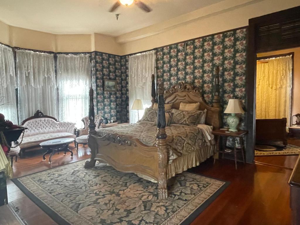 a bedroom with a large bed and a living room at Grand Gables Inn in Palatka