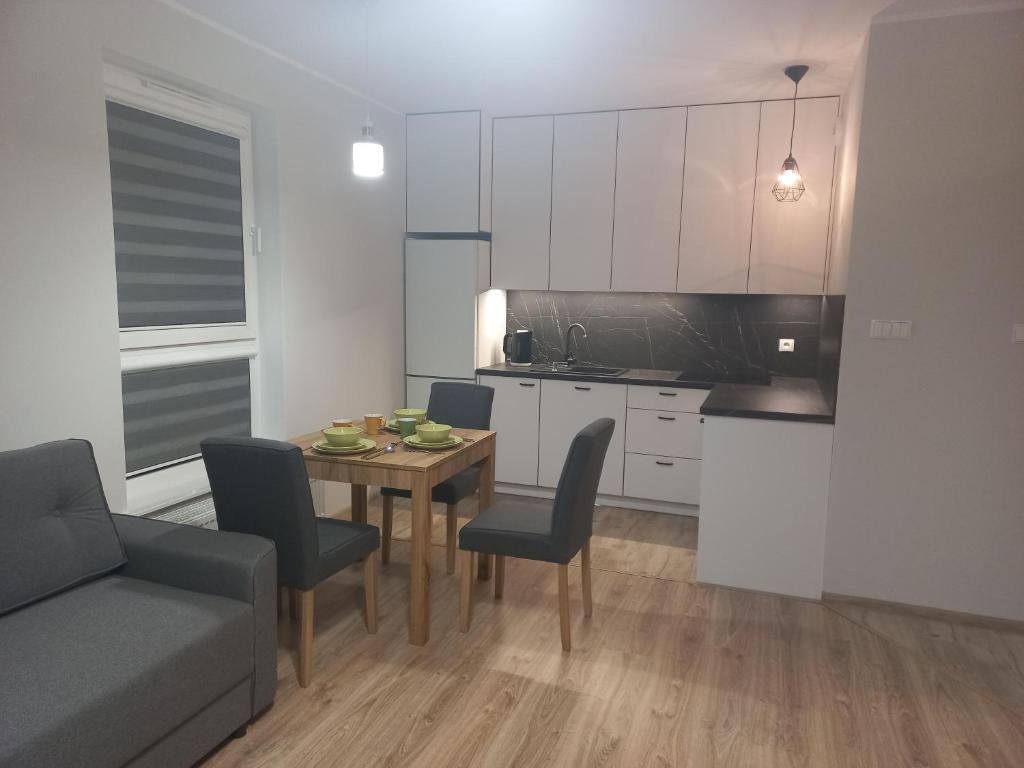 eine Küche und ein Esszimmer mit einem Tisch und Stühlen in der Unterkunft Apartament Rumia z Garażem in Rumia