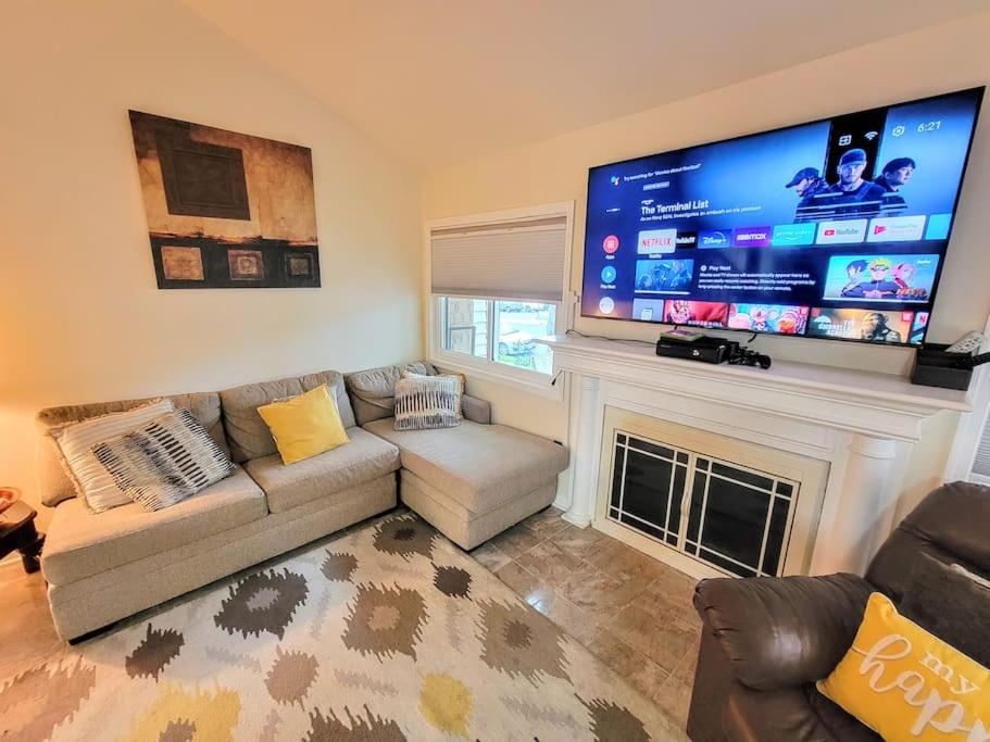 a living room with a couch and a large screen tv at Nice 2BDR near Airport with fast WiFi / Metro / Parking in Herndon