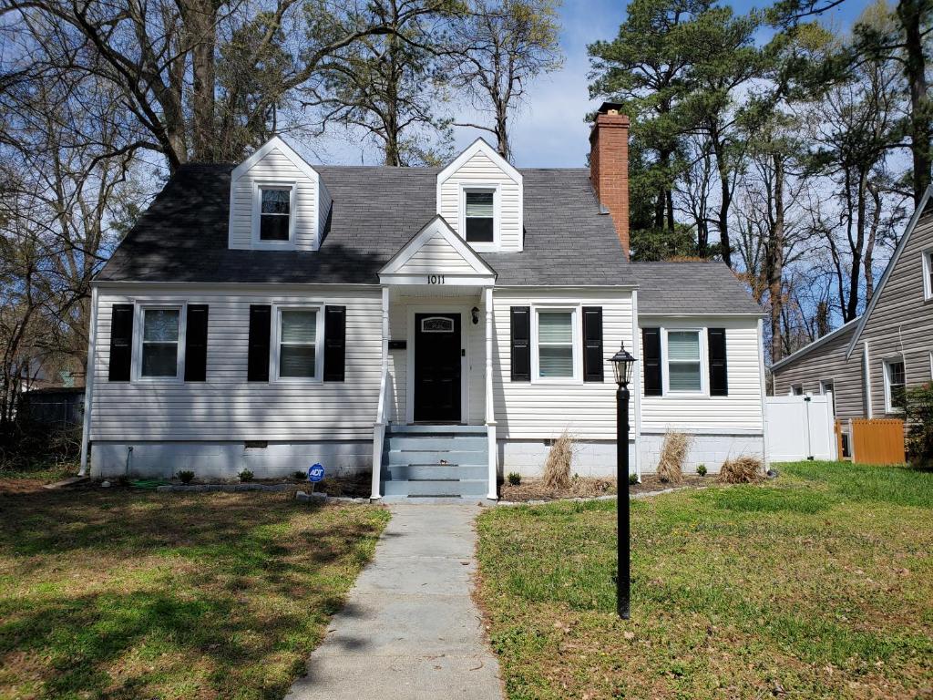 a white house with a black door and a driveway at Weyanoke in Petersburg