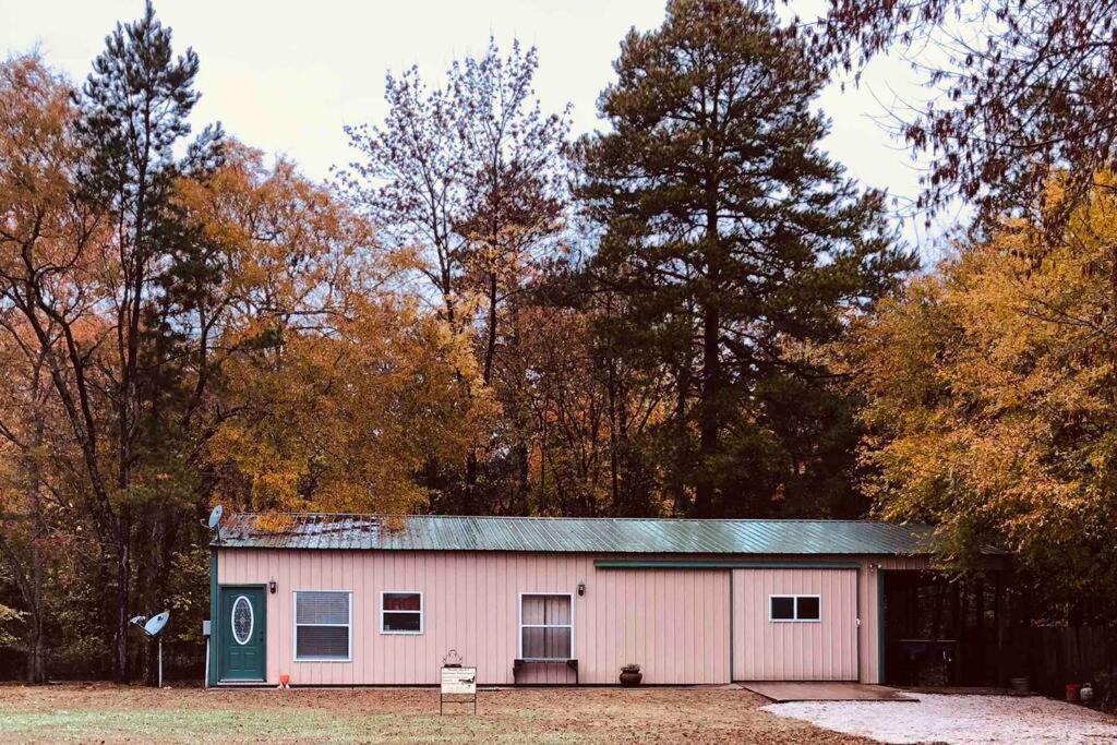 un edificio blanco y verde frente a los árboles en Happy Jack’s Outdoor Adventures, en Calico Rock