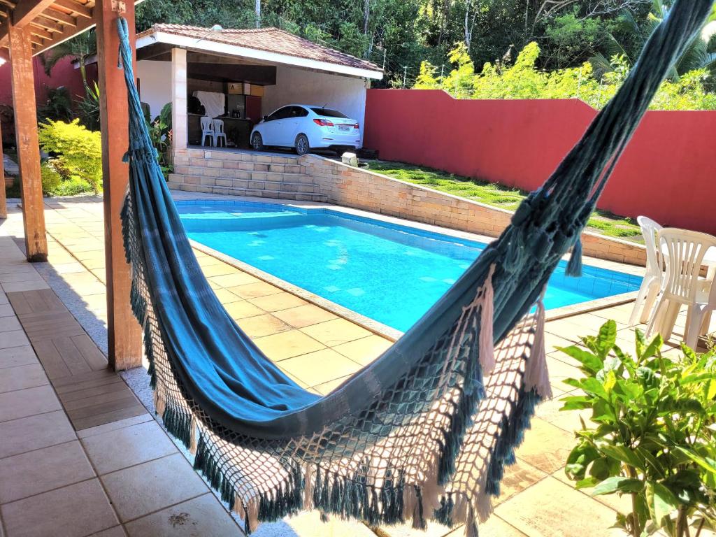 a hammock on a patio next to a swimming pool at Casa de praia / piscina in Santa Cruz Cabrália