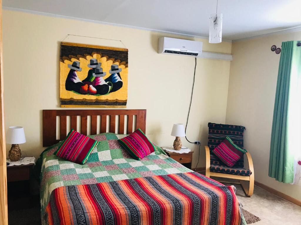 伊基克的住宿－Casa con Piscina privada en Pica，一间卧室配有一张带彩色毯子的床