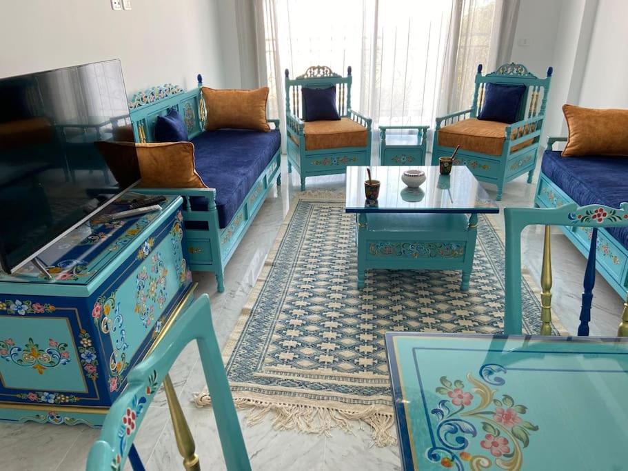 ラ・マルサにあるMarsa Central Splendid Appart 2の青いソファとテーブルが備わる客室です。