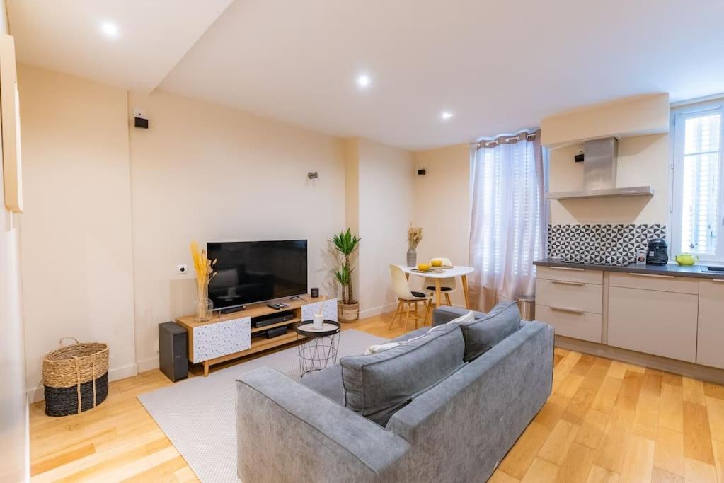 ein Wohnzimmer mit einem Sofa und einer Küche in der Unterkunft Magnifique appartement à 10 min de l'aéroport Orly in Villeneuve-le-Roi