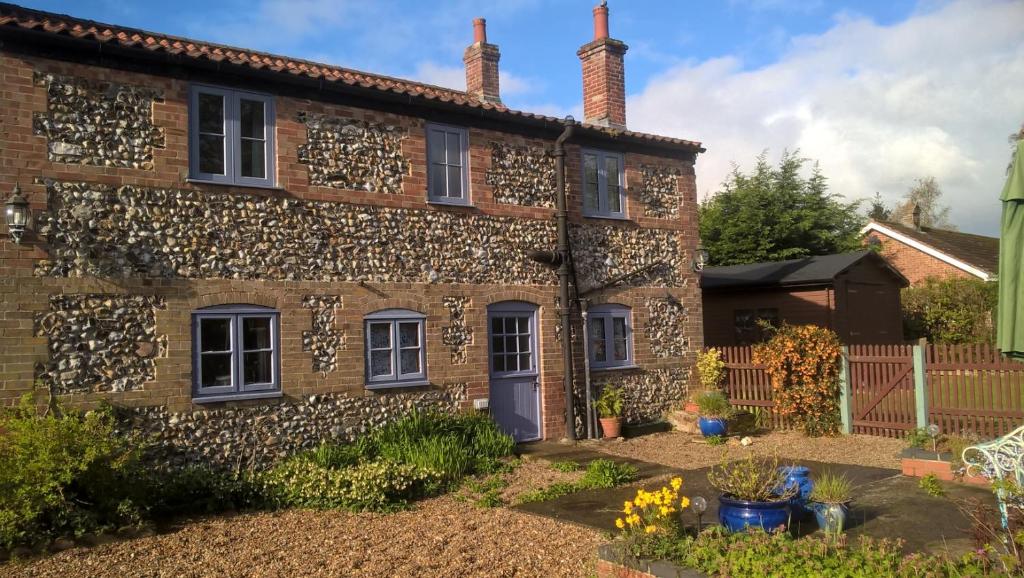 una antigua casa de piedra con un jardín delante de ella en Stone House Farm (Adults Only), en Lyng