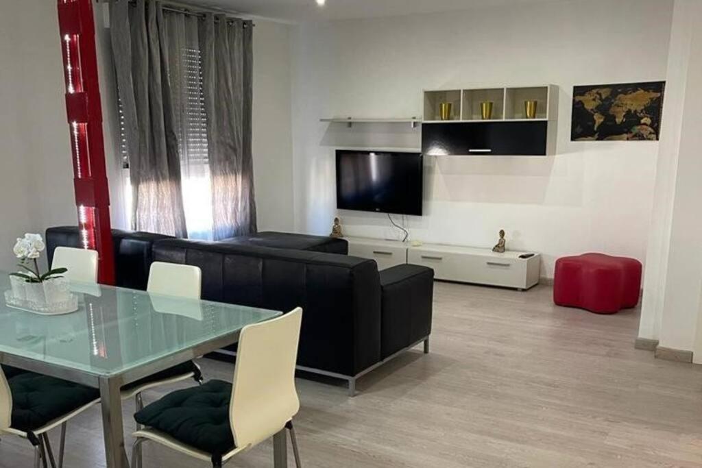 un soggiorno con divano nero e tavolo di Lujoso y amplio apartamento en Crevillente a Crevillent