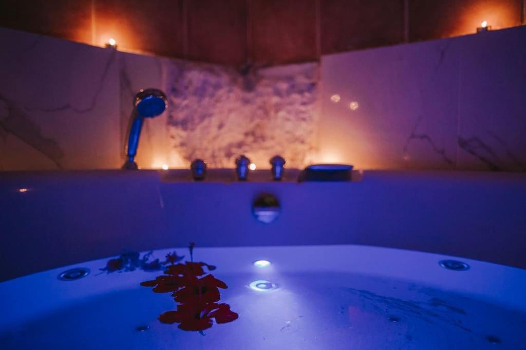 a bathroom with a sink with purple lights in it at PRECIOSA CASA-CUEVA CON JACUZZI in Paterna