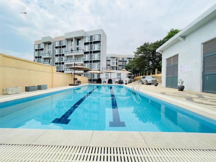 a large swimming pool in front of a building at Embassy Access Golf Apartment in Kigali