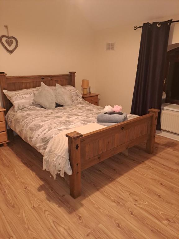 Schlafzimmer mit einem Holzbett und Holzboden in der Unterkunft Barrow mews views in Carlow